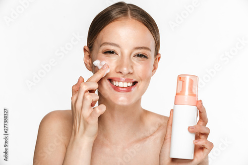 Schilderij op canvas Image of beautiful half-naked woman smiling while washing her face with foaming