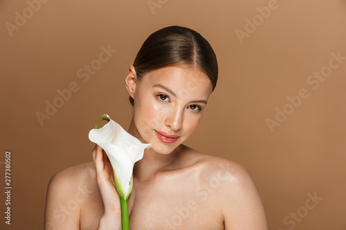 Image of beautiful half-naked woman looking at camera and holding white flower