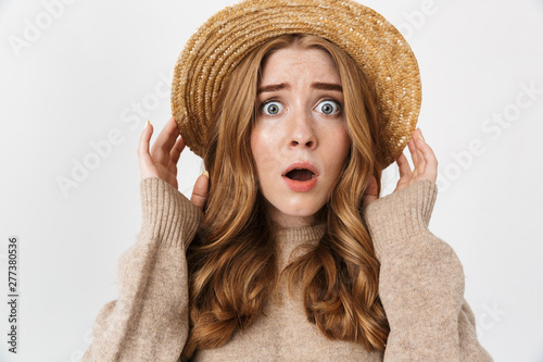 Shocked emotional young teenage girl posing isolated over white wall background wearing hat.
