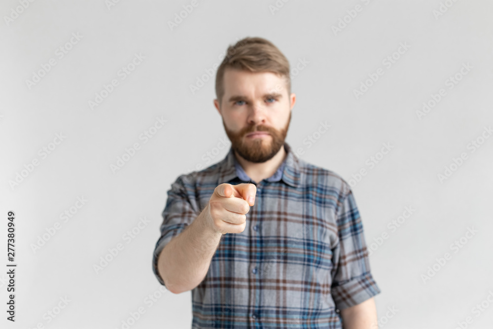 Fototapeta premium Serious student man showing on the camera on white background