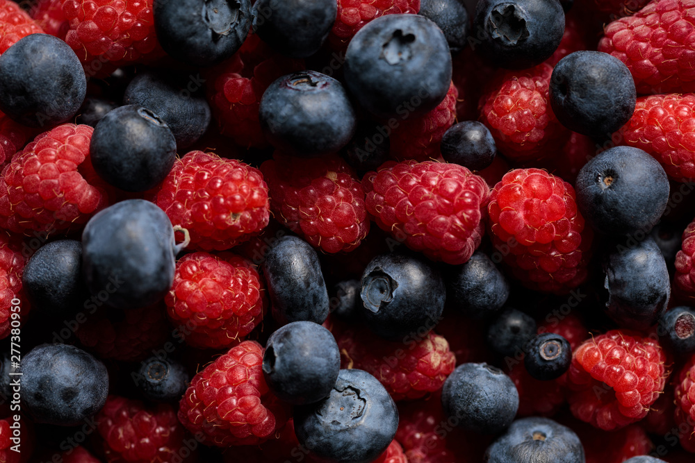 close up view of delicious and fresh ripe mixed raspberries and blueberries close up view of delicious and fresh ripe mixed raspberries and blueberries