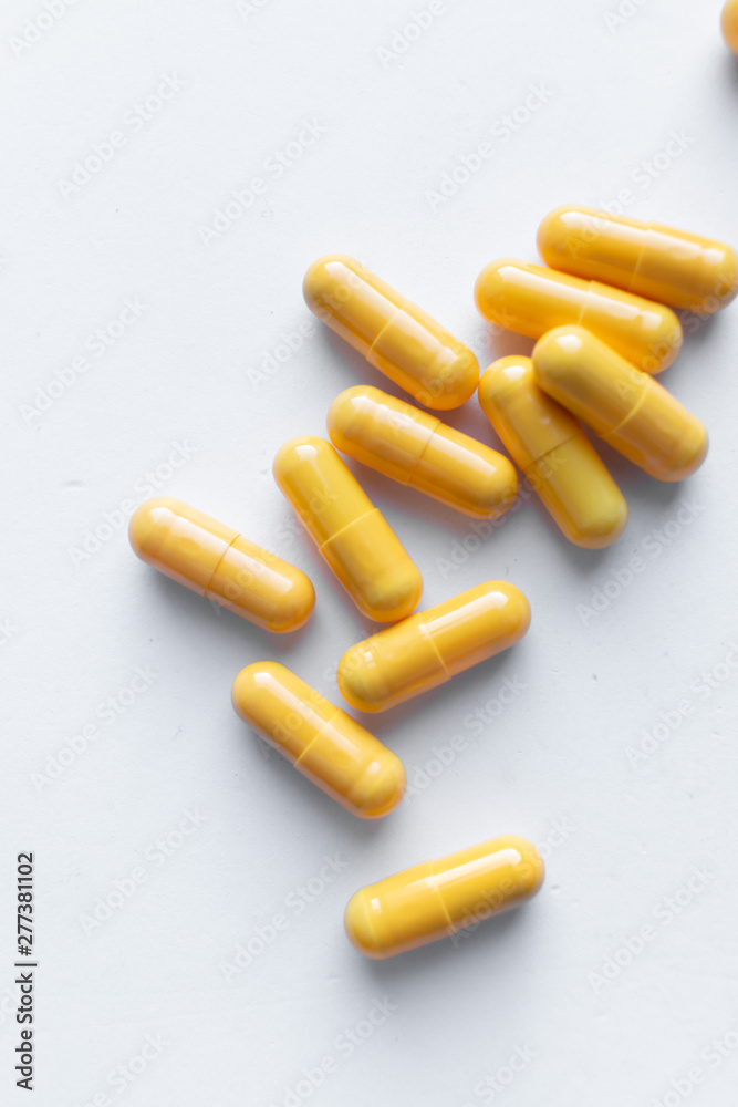 Scatterded yellow pills on white background Scatterded yellow pills on white background