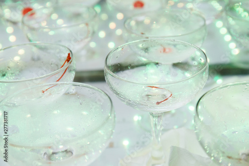 empty champagne glasses on the table with LED illumination. bar table after the party with transparent glass glasses and the remnants of champagne. concept of a fun party, celebration, wedding, prom
