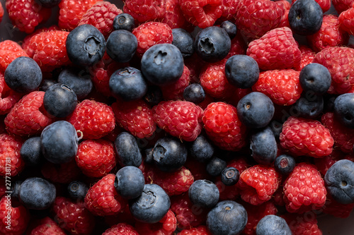 close up view of fresh ripe mixed raspberries and blueberries