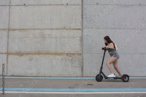Teenage girl circulating with an electric scooter