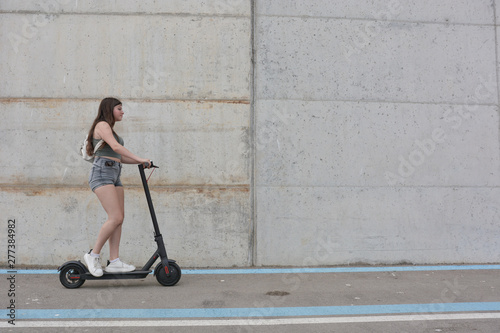 Teenage girl circulating with an electric scooter