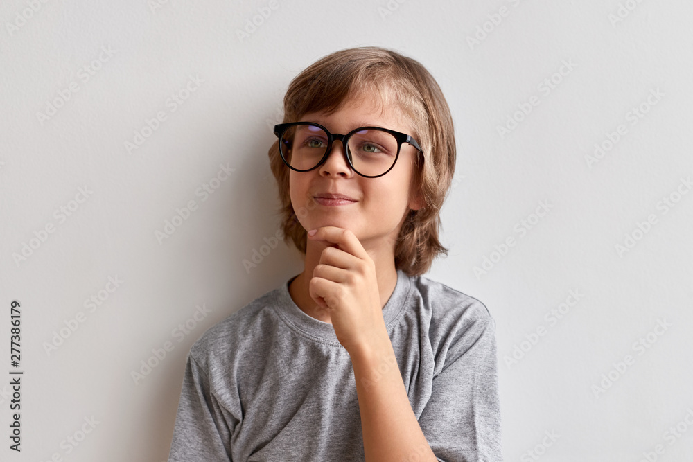 Thoughtful youngster rubbing chin - obrazy, fototapety, plakaty 
