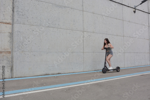 Teenage girl circulating with an electric scooter