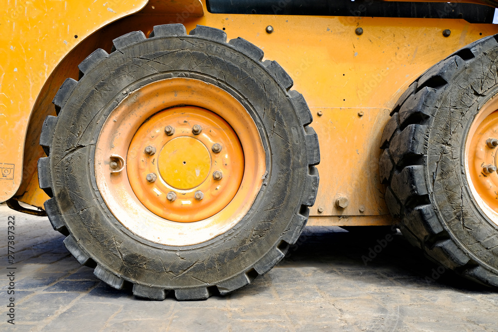 A rear tyre, heavy duty construction site diesel excavator.