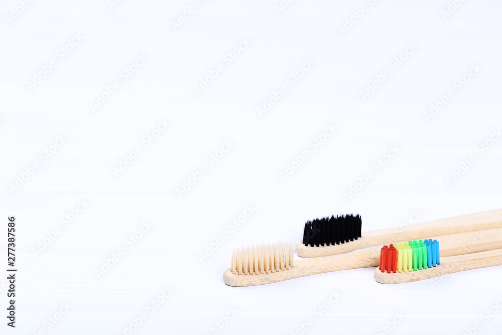 Bamboo toothbrushes on white wooden table Bamboo toothbrushes on white wooden table