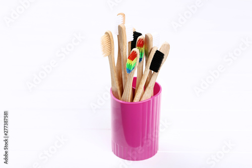 Bamboo toothbrushes in basket on white wooden table
