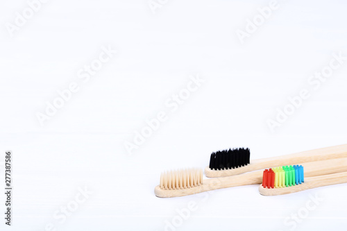 Bamboo toothbrushes on white wooden table