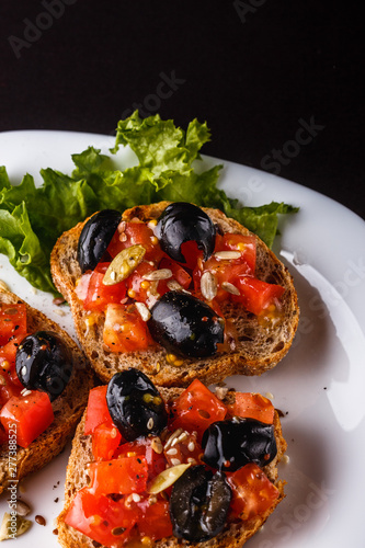 Canvastavla Italian bruschetta with tomato, black olives, lettuce and mustard