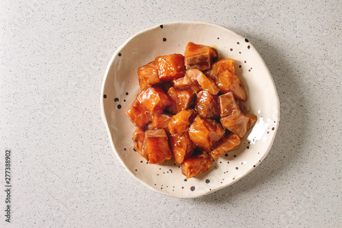 Billede på lærred Cutting salmon fish soy sauce marinated in ceramic plate over grey spotted background
