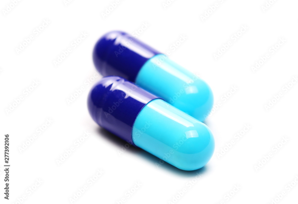Blue pills macro, medicine isolated on white background