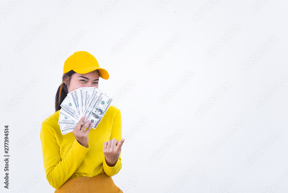 Portrait of beautiful asian woman in yellow cloths on dirty white wall,Hipsters girl wear yellow hat take a picture,Thailand people have a lot dollar money in hand Portrait of beautiful asian woman in yellow cloths on dirty white wall,Hipsters girl wear yellow hat take a picture,Thailand people have a lot dollar money in hand