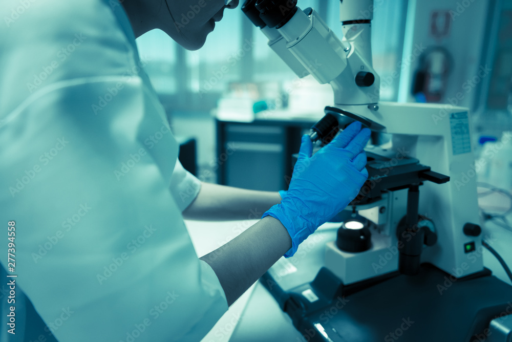 Young asian scientist looking through a microscope in a laboratory.Thailand people doing some research. Young asian scientist looking through a microscope in a laboratory.Thailand people doing some research.