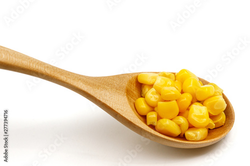 Corn seeds in a wooden spoon isolated on white background