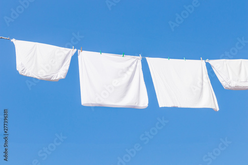 close up of pillow cases hanging for dry with the sun with background of blue sky in summer. 