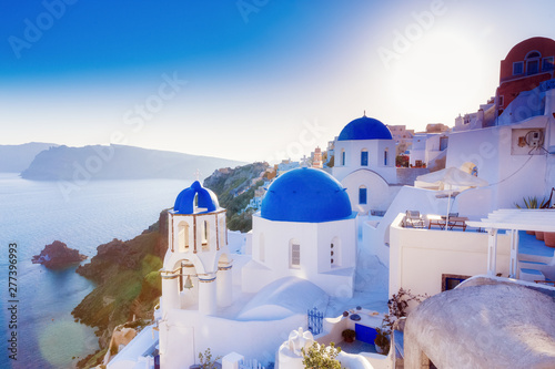 Santorini, Greece. Charming view Oia village on Santorini island. Traditional famous blue dome church over the Caldera in Aegean sea. Traditional blue and white Cyclades architecture.