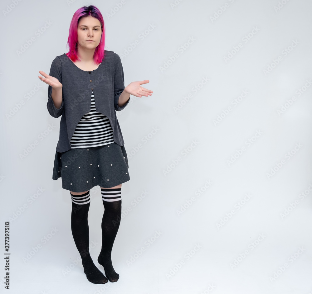 Full-length portrait of young pretty teenager girl in gray suit with beautiful purple hair on a white background in the studio. Talking, smiling, showing hands with emotions. Full-length portrait of young pretty teenager girl in gray suit with beautiful purple hair on a white background in the studio. Talking, smiling, showing hands with emotions.