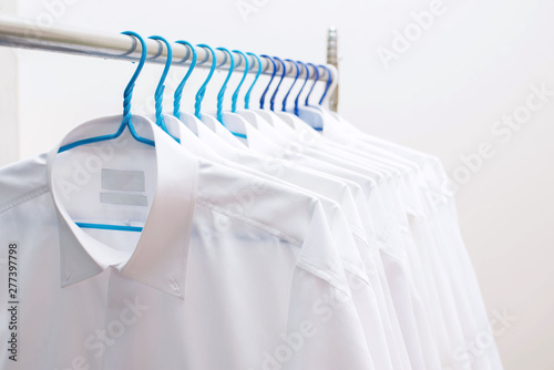 White shirts hanging on rack in a row
