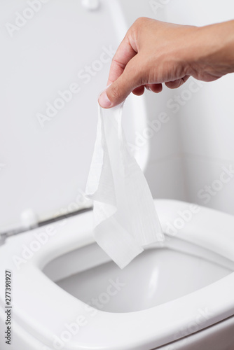 Fototapeta Naklejka Na Ścianę i Meble -  man throwing a wet wipe to the toilet