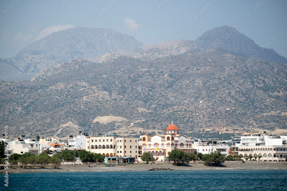 Obraz premium Ierapetra, Crete, Greece. June 2019. The southern coastal town of Ierapetra and the church of Agia Fotini with a mountain backdrop