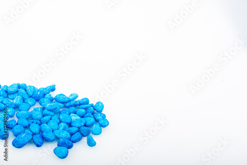 Blue pebbles stone with empty copyspace area for slogan or advertising text message, over isolated white background.