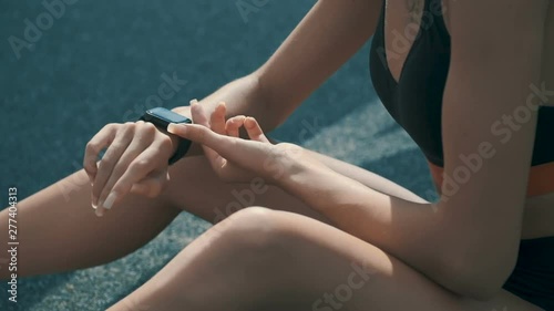 Female sportsman setting up smart watch photo