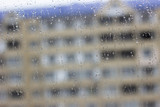 Close up shot of rain drops on glass window against sunset. Raindrops on window against a light background. Raindrops on the window