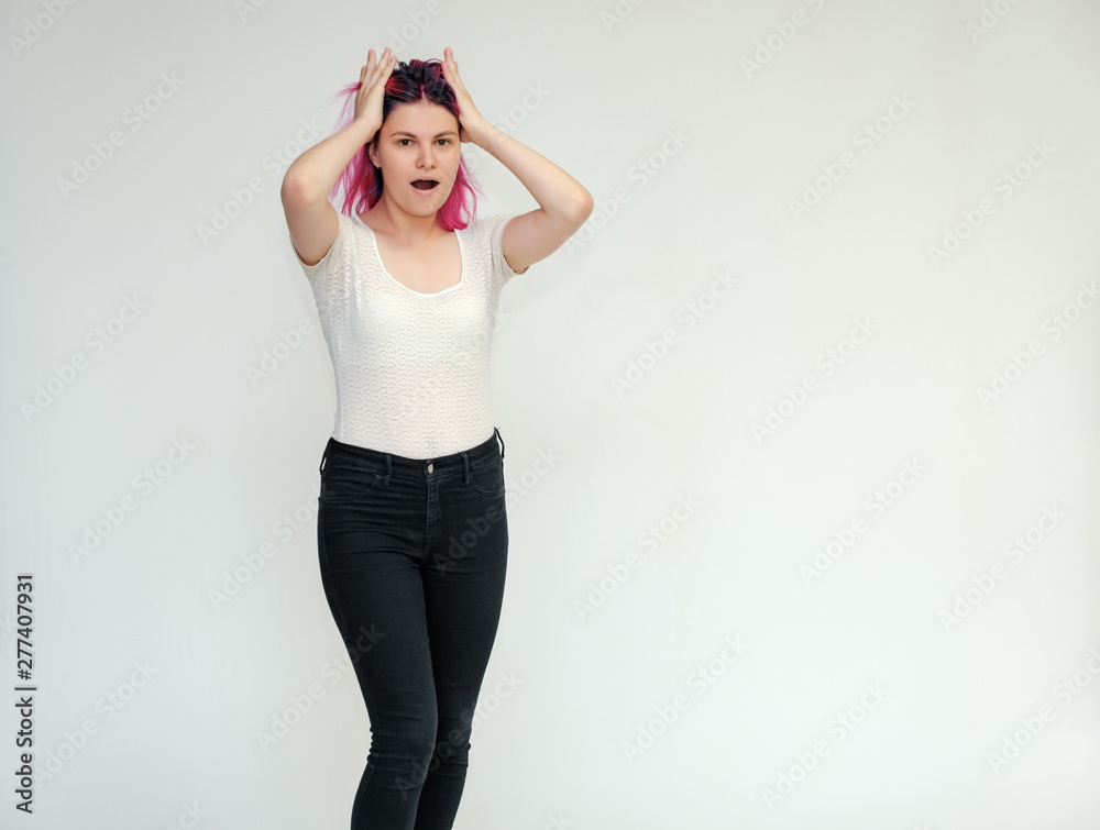 Portrait below the knee of a young beautiful girl teenager in a white T-shirt and black jeans with beautiful purple hair on a white background in the studio. They say, they smile, they show hands Portrait below the knee of a young beautiful girl teenager in a white T-shirt and black jeans with beautiful purple hair on a white background in the studio. They say, they smile, they show hands