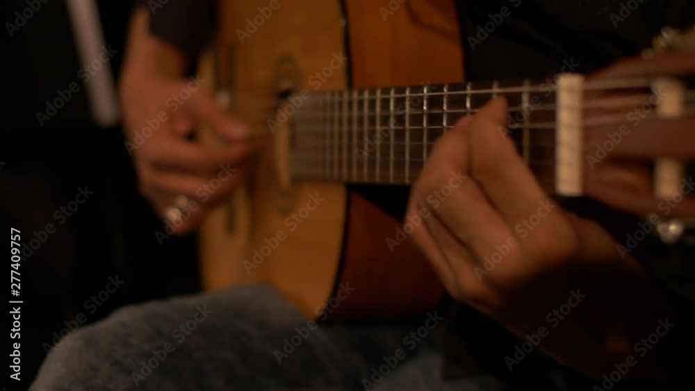 Close-up of an acoustic guitar being played by a skilled musician during a concert.