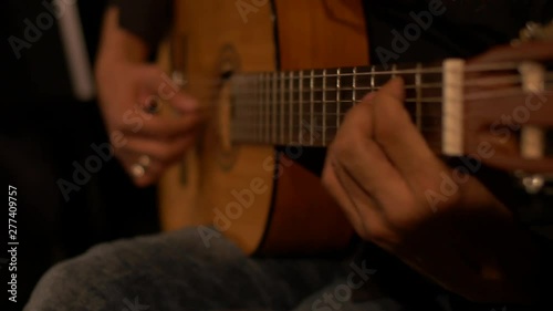 Close-up of an acoustic guitar being played by a skilled musician during a concert.