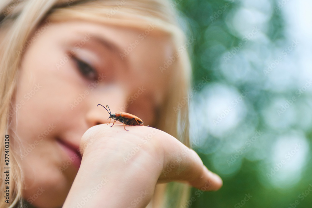 Child girl examining a beetle on her hand Child girl examining a beetle on her hand
