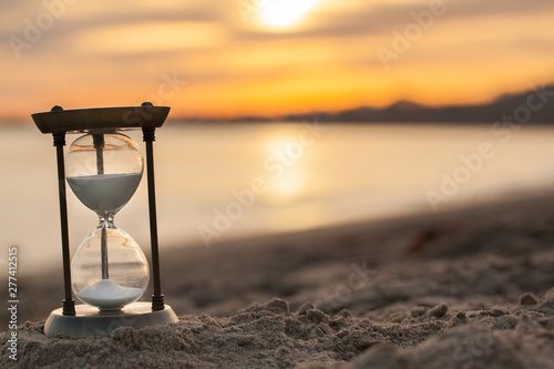 Sand running through the bulbs of an hourglass measuring the passing time in a countdown to a deadline with copy space.