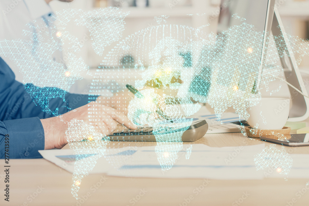 Fototapeta premium Double exposure of businessman working on laptop on background. International business hologram in front. Concept of success.