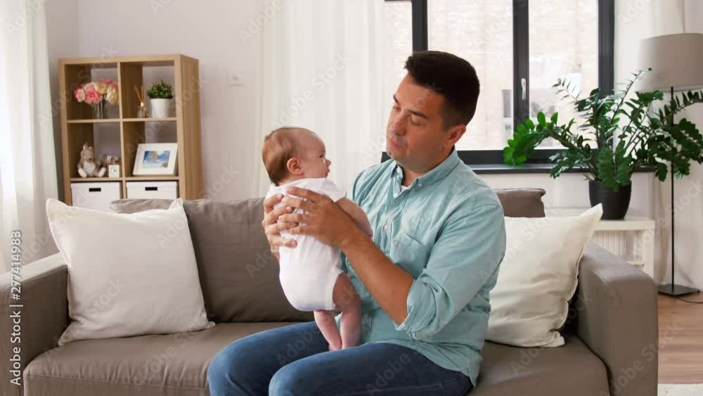 family, parenthood and fatherhood concept - middle aged father comforting little baby daughter at home family, parenthood and fatherhood concept - middle aged father comforting little baby daughter at home