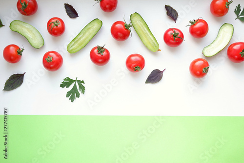 Cherry tomatoes and cucumbers in a cut on a white background. View from above