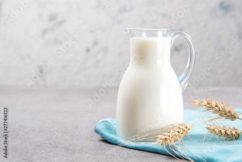 Milk jug on a table, closeup with a copy space