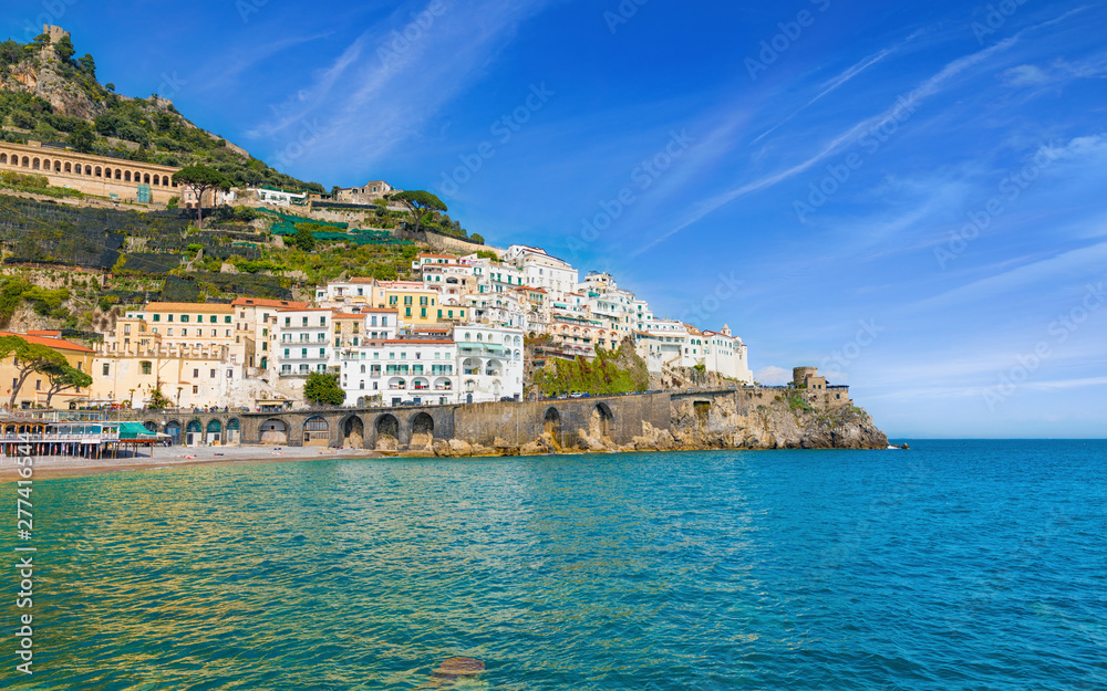 Beautiful Amalfi on hills leading down to coast, comfortable beaches and azure sea on Amalfi Coast in Campania, Italy