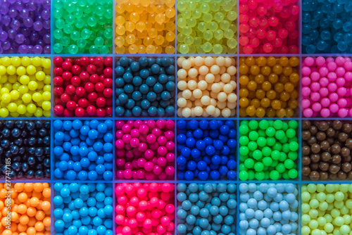 Many small beads are arranged in the box