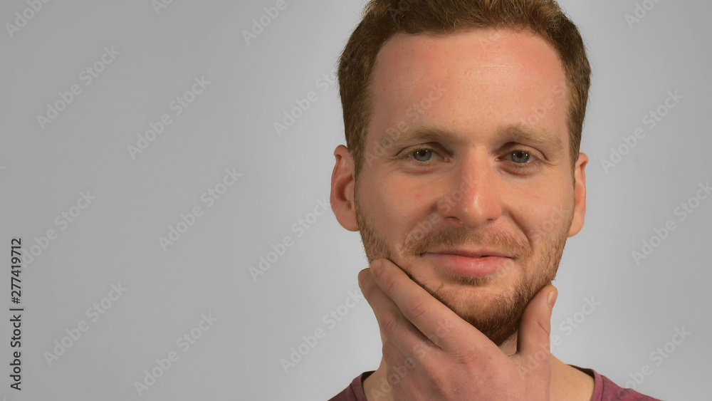 caucasian guy with red hair posing scratching his beard handsome redhead men wearing in casual t-shirt. Portrait hipster young caucasian man on grey background caucasian guy with red hair posing scratching his beard handsome redhead men wearing in casual t-shirt. Portrait hipster young caucasian man on grey background
