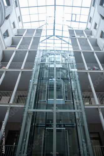 Large glass elevator in a room with a glass ceiling