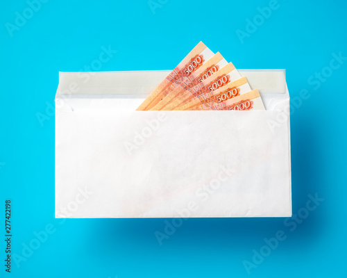 White envelope with cash ruble banknotes on light blue background