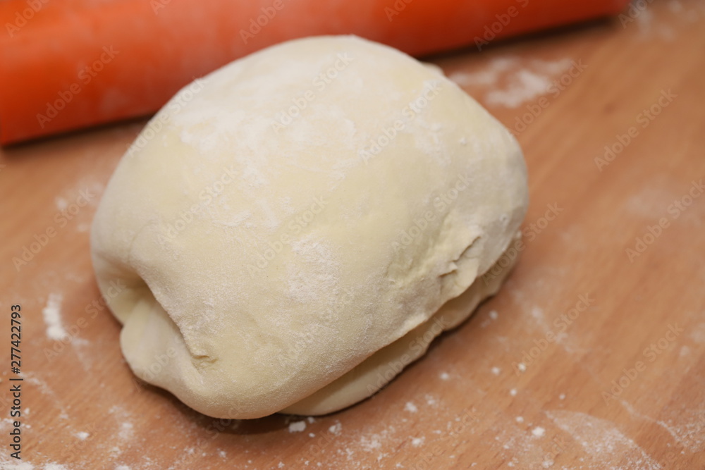 White flour dough is on the table. White flour dough is on the table.
