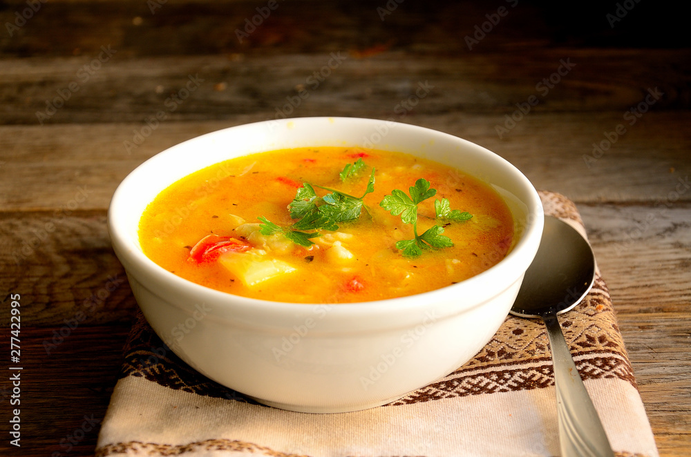 Vegetarian soup with vegetables and pasta on a wooden table. Vegetarian soup with vegetables and pasta on a wooden table.