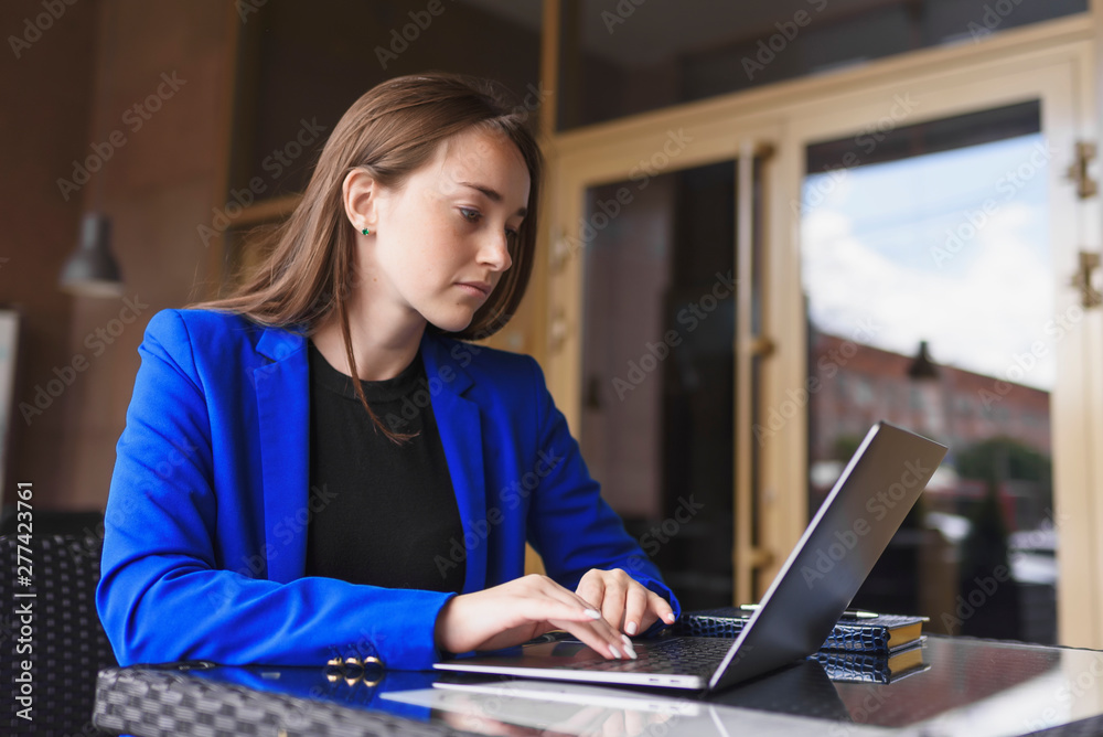 Business woman in a jacket working behind a laptop Business woman in a jacket working behind a laptop