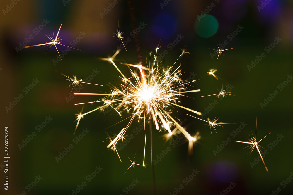 Obraz premium Sparks from hand cold fireworks color background
