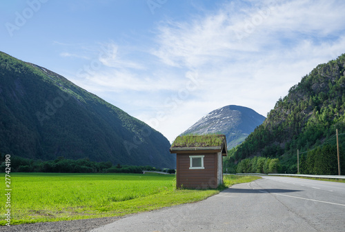 Panoramic view from the road E70 at the egg shaped peak in the mountain range in the Sunndalen valley. Bus stop house in front. Norway, Europe. photo